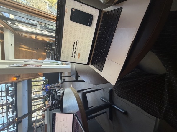 User working from a café while their Homard Cloud AI agent handles tasks